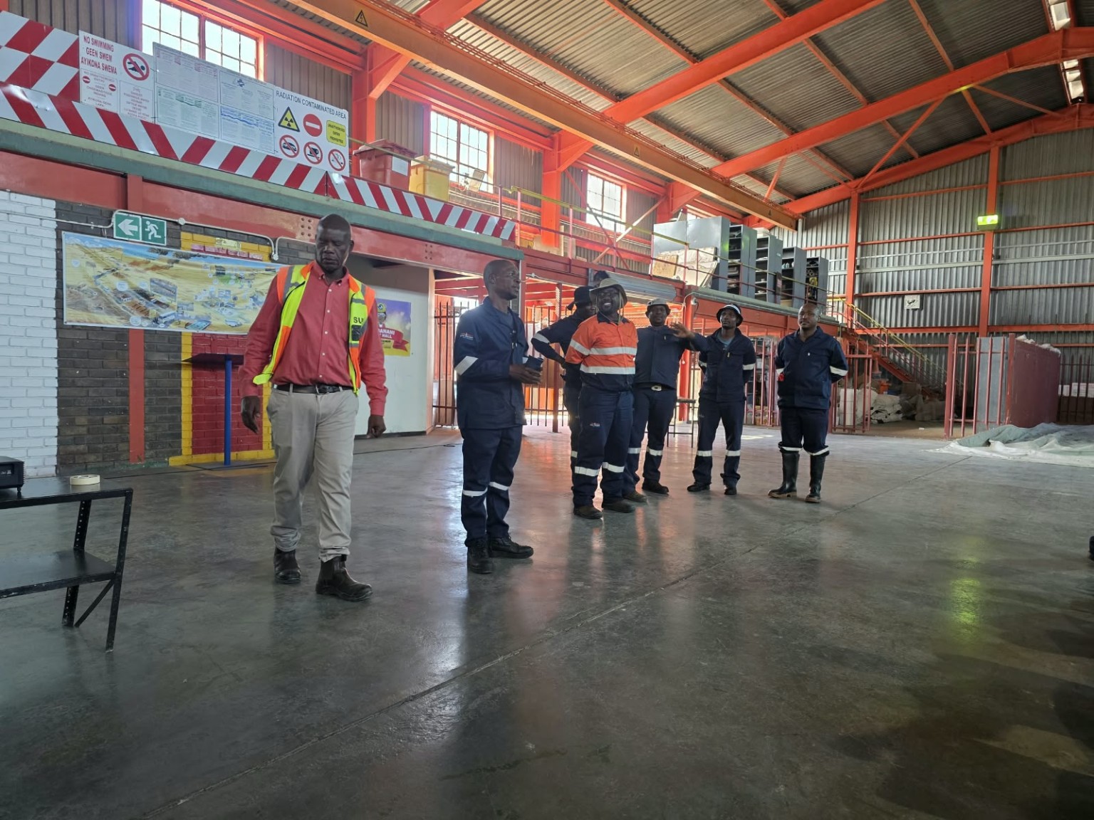 People in workwear standing inside an industrial workshop